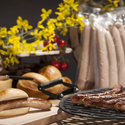 Original Thüringer Rostbratwurst gegrillt und roh auf einem Tisch.